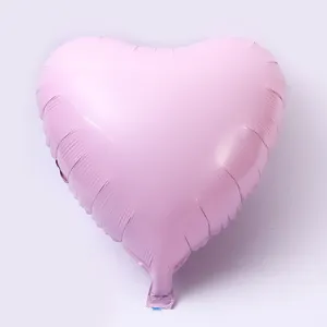 Pink heart foil balloon close up detail shot, smooth metallic texture for party decor display.