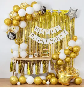 Detailed scene of birthday party balloons and gold fringe curtain decoration setup.