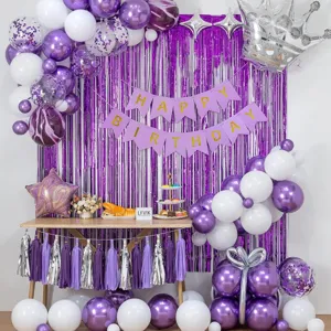 Purple and white birthday party balloon decoration set with foil fringe curtain backdrop.