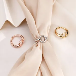 Primo piano dettagliato di anelli per sciarpa in metallo lucido minimalista oro, argento, oro rosa.