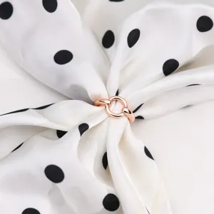 Primo piano dettagliato di un anello per sciarpa intrecciato in oro rosa elegante.