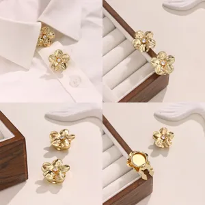 Dettaglio ravvicinato di copribottoni floreali dorati con zircone luminoso elegante.