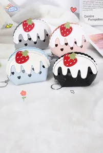 Detail view of cute strawberry ice cream mini coin purse with heart cutouts and keychain.