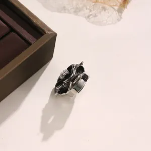 Primo piano dettagliato di uno squisito bottone camelia nera, dettaglio elegante per polsino.