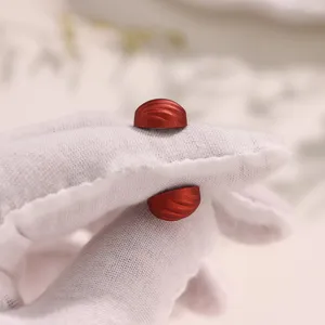 Detailopname van de rode magnetische hoofddoekspeld met gestructureerd oppervlak voor sjaals.