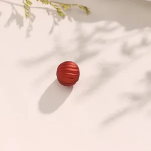 Rood magnetische sluiting detail, ronde gegroefde metalen clip, sjaal accessoire close-up.
