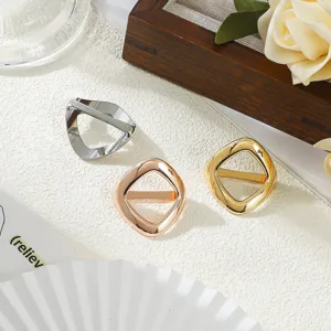 Dettaglio fibbia per sciarpa geometrica in metallo, elegante accessorio di moda lucido.