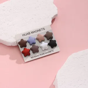 Close-up of star-shaped hijab magnets set on display card, colorful magnetic pins for scarves.