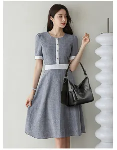 Close-up detail view showing a stylish grey dress paired with an elegant black shoulder bag.