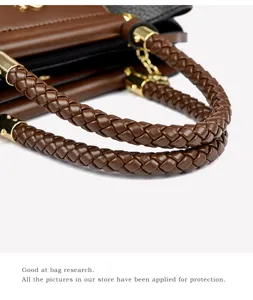 Detailed view of brown braided handbag handle, premium leather tote bag stylish accessory.