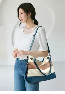 Detailed view of the stylish color-blocked commuter shoulder handbag worn by the model.