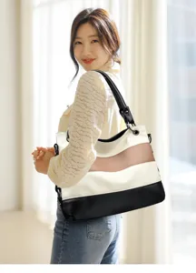 Detail shot of stylish color-block shoulder tote bag showcasing design and texture for women.