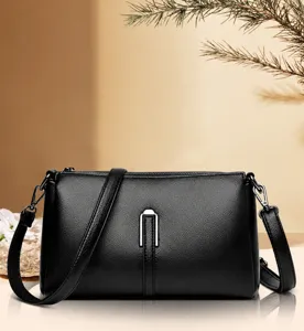 Detailed shot of a chic black leather crossbody bag for women with metal U-shaped clasp.