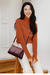 Detailed view of the soft leather maroon crossbody bag, featuring a sleek metal clasp and strap.