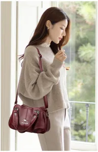Sac a main pour femme elegante en cuir rouge vin sac bandouillere avec details metalliques.