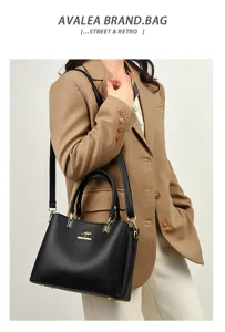 Elegant black leather handbag detail with gold hardware and shoulder strap fashion design.