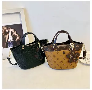Detailed view of retro bucket shoulder bag with monogram print and chic floral charm accent.
