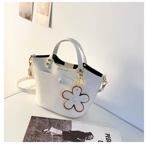 Stylish white leather bucket bag for women, versatile crossbody shoulder bag with cute flower charm.