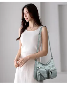 Vista dettagliata della borsa a tracolla da donna verde salvia con comode tasche multiple.