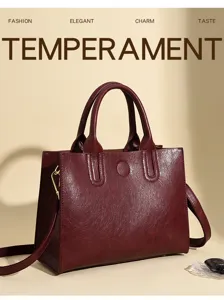 Detail view of vintage burgundy oil wax leather tote bag with sturdy handles and metal hardware.