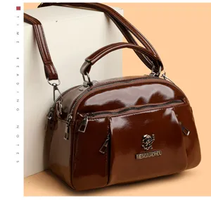 Dark brown patent leather women crossbody shoulder handbag with top handle and dual zippers.