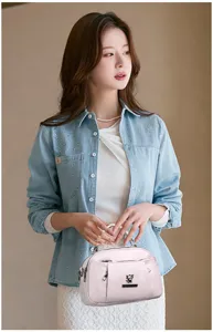 Chic pink women handbag detail, elegant leather crossbody shoulder bag with stylish metal logo.