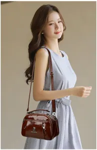 Stylish women patent leather shoulder bag crossbody handbag with metal zipper and handle.