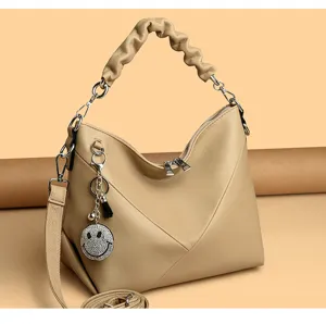 Chic beige women's shoulder bag with ruched handle and rhinestone smiley charm.