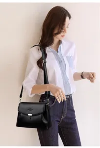 Detailed shot of black PU leather shoulder bag with flap closure and elegant metal clasp accent.