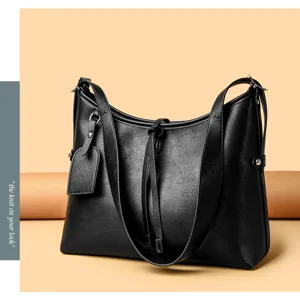Detail view of the black PU leather shoulder bag featuring adjustable straps and stylish drawstring.