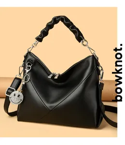 Detailed view of black leather shoulder bag with stylish gathered handle and silver hardware.