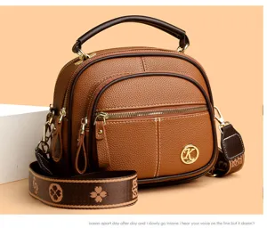 Brown soft leather dome crossbody bag with multi-layers, top handle and patterned strap.