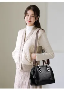 Detailed shot of a stylish black leather shoulder handbag showcasing multi-layer design and craft.