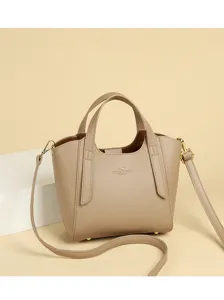 Detailed view of a stylish beige PU leather handbag with top handles and shoulder strap.