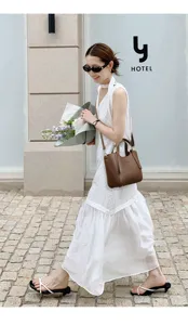 Detailed view of a trendy brown leather bucket bag, chic daily commuter crossbody design.