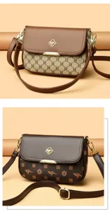Élégant sac bandoulière pour femme avec motif monogramme élégant et quincaillerie dorée.