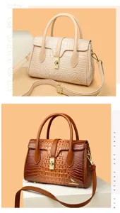 Detail view of women's crocodile textured PU leather handbag with metal lock and strap.