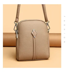 Stylish women crossbody shoulder bag in solid khaki leather with chic front hardware charm.