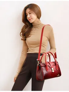 Red crocodile pattern patent leather handbag detail, elegant shoulder bag with metal lock buckle.