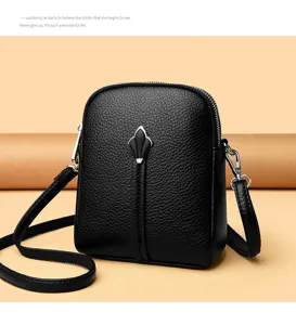 Black leather crossbody small bag, detailed view of the chic vertical front metal ornament.
