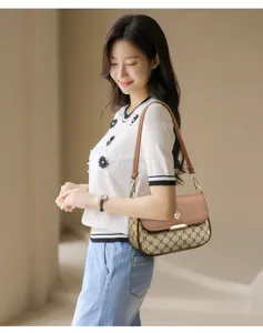 Élégant sac à bandoulière en cuir marron avec toile monogramme et fermoir métallique.