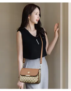 Sac à bandoulière élégant pour femme avec motif monogramme et fermoir métallique en trèfle.