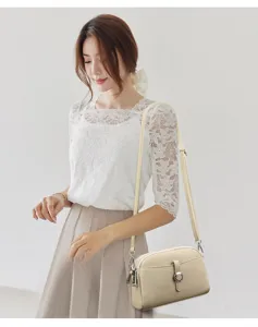 Detailed view of the women's beige leather crossbody shoulder bag featuring chic hardware.