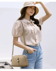 Detail shot of a stylish crossbody shoulder bag worn by an Asian model in casual daily wear.