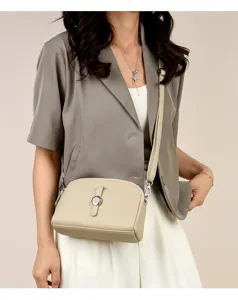 Stylish women's crossbody shoulder bag in beige leather with chic metal buckle design.
