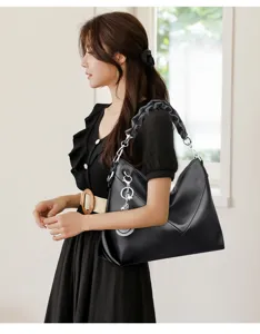 Stylish black shoulder bag for women, featuring pleated strap and chic metal chain pendant.