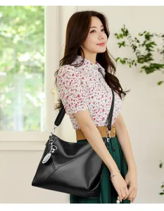 Black leather shoulder bag for women, stylish geometric panel design crossbody handbag.