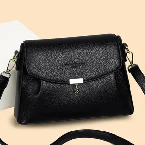 Black PU leather women's shoulder bag with chic flap, gold hardware and leaf pendant.
