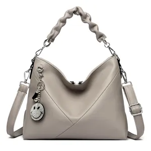 Elegant grey leather women shoulder bag with chic ruffled handle and cute smiley pendant.
