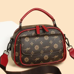 Stylish brown women shoulder bag featuring kangaroo pattern and red leather handles and straps.